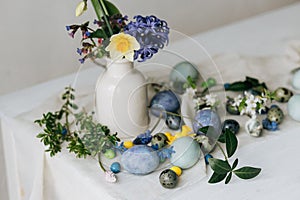 Stylish easter eggs and spring flowers on rustic wooden table. Happy Easter! Natural dye marble and blue eggs, purple hiacynt