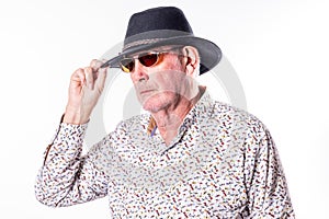 Stylish Elderly Man Adjusting Fedora Hat