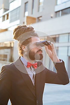 Stylish elegant dreadlocks businessman binoculars