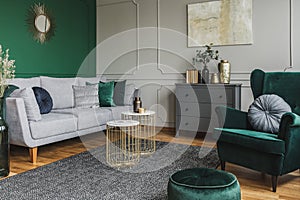 Stylish emerald green and grey living room interior design with abstract painting on the wall photo