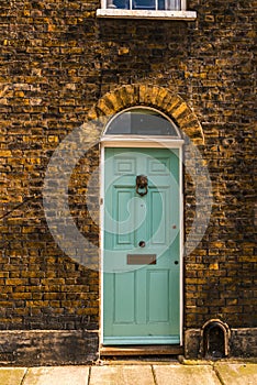 stylish entrance to a residential building, an interesting facade of the old brick arches above the door, a typical old English b