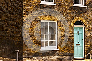 stylish entrance to a residential building, an interesting facade of the old brick arches above the door, a typical old English b