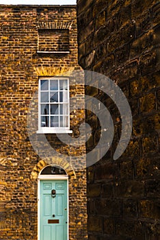 stylish entrance to a residential building, an interesting facade of the old brick arches above the door, a typical old English b