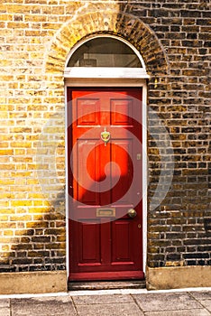 stylish entrance to a residential building, an interesting facade of the old brick arches above the door, a typical old English b