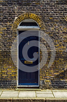 stylish entrance to a residential building, an interesting facade of the old brick arches above the door, a typical old English b