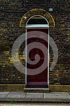 stylish entrance to a residential building, an interesting facade of the old brick arches above the door, a typical old English b