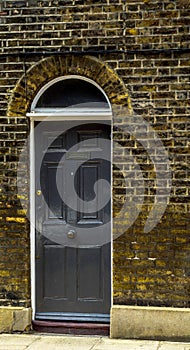 stylish entrance to a residential building, an interesting facade of the old brick arches above the door, a typical old English b