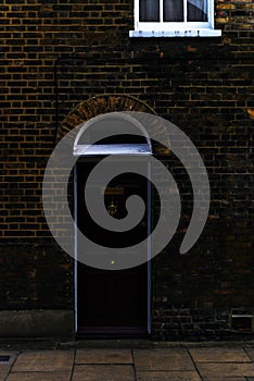 stylish entrance to a residential building, an interesting facade of the old brick arches above the door, a typical old English b