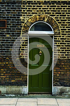 stylish entrance to a residential building, an interesting facade of the old brick arches above the door, a typical old English b
