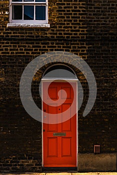 stylish entrance to a residential building, an interesting facade of the old brick arches above the door, a typical old English b