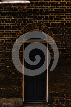 stylish entrance to a residential building, an interesting facade of the old brick arches above the door, a typical old English b