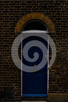 stylish entrance to a residential building, an interesting facade of the old brick arches above the door, a typical old English b