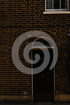 stylish entrance to a residential building, an interesting facade of the old brick arches above the door, a typical old English b