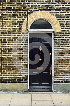 stylish entrance to a residential building, an interesting facade of the old brick arches above the door, a typical old English b