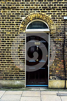 stylish entrance to a residential building, an interesting facade of the old brick arches above the door, a typical old English b