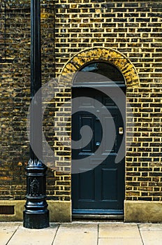 stylish entrance to a residential building, an interesting facade of the old brick arches above the door, a typical old English b