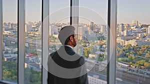 Stylish executive looking window rear view. Pensive businessman admiring city