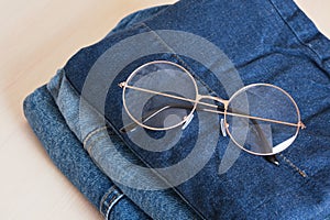 stylish eye glasses on a stack of jeans