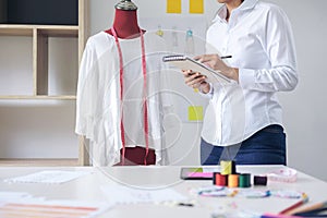 Stylish fashion designer working with measure red dummy