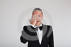 Stylish fashion portraits of a charismatic handsome man in a black tuxedo suit with a bow tie. Emotions, dramatic, close-up.