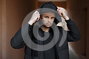 Stylish fashionable young man in a trendy black baseball cap