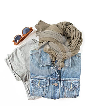 Stylish female clothes set. Woman/girl outfit on white background. Blue denim jacket, gray t-shirt, scarf and retro sunglasses. Fl