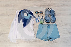 Stylish female clothing set with accessories: white blouse, blue scarf, jeans shorts, leather sandals, perfum, eyeshadows and nail