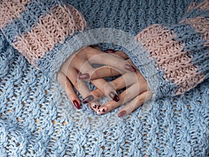 Stylish female manicure. Young female hands in woolen material