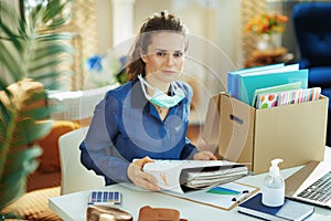 Stylish female with medical mask organising home office