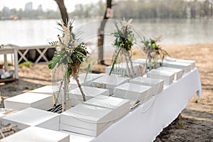 Stylish festive wedding table served with food boxes and decorated with fresh tropical flowers