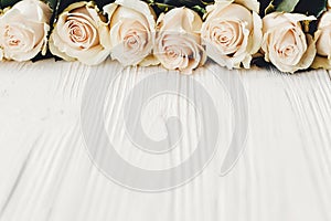 Stylish Floral greeting card mockup. White roses on wooden background, copy space for text. Wedding invitation or happy mother da