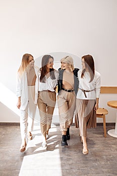 Stylish four young women friends having fun at the cafe indoors.