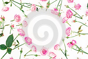 Stylish frame made of pink roses, buds and leaves on white background. Floral pattern. Flat lay, Top view.