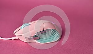 Stylish gaming mouse. Pink computer mouse. Game mouse pink color, blurred background. Esports concept