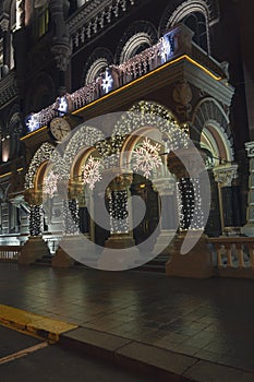 Stylish garland lights at front of a building at european city street. Festive street decor