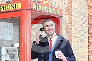 Stylish gentleman calling from vintage payphone