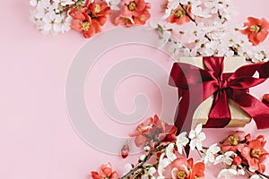 Stylish gift box with flowers on pink background flat lay. Happy Mothers day. Greeting card template with space for text. Craft