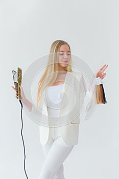 Stylish girl with curling iron on white background