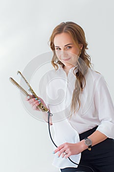 Stylish girl with curling iron on white background