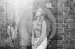 Stylish girl near brick textured wall, beauty and fashion