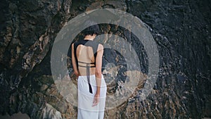 Stylish girl spinning beach at seaside cliffs. Professional fashion model posing