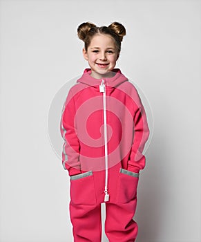 stylish girl in a sports pink suit. little schoolgirl stands in full growth on a white background. hip hop dancers wear