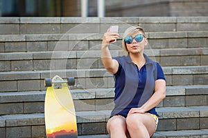 Stylish girl in sunglasses takes a selfie