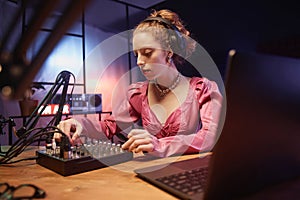 Stylish Girl Using Audio Mixer at Podcast