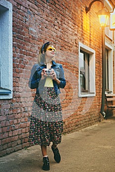 Stylish girl walking with vintage camera