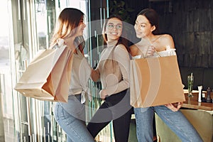 Stylish girls standing in a cafe with shopping bags