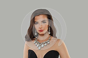Stylish glamorous woman jewelry model with diamonds posing on gray background