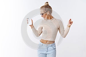 Stylish glamour and carefree caucasian woman in cropped sweater glasses turning away joyfully waving hands in dance