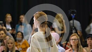 Light brown hair girl walks on catwalk podium. Women fashion vogue runway defile photo