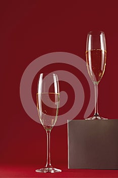 Stylish glasses of champagne on a stand on a red background